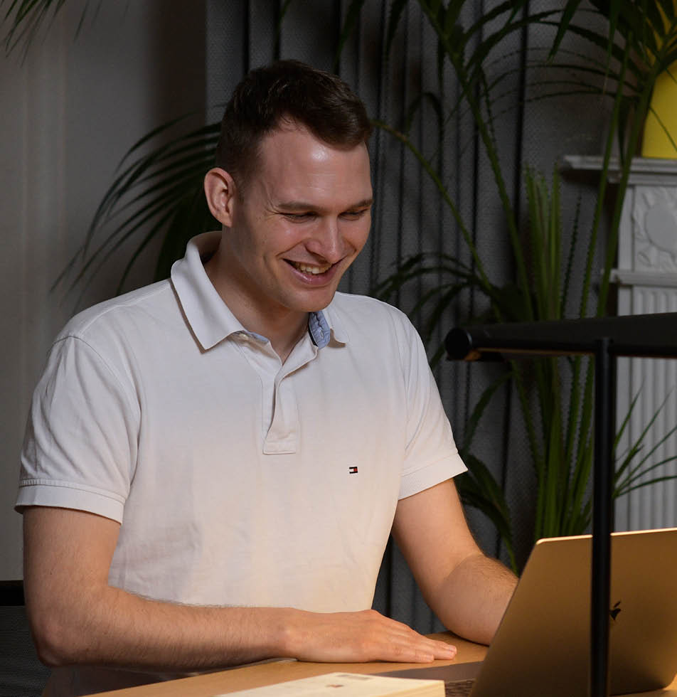 Man smiling looking at a laptop