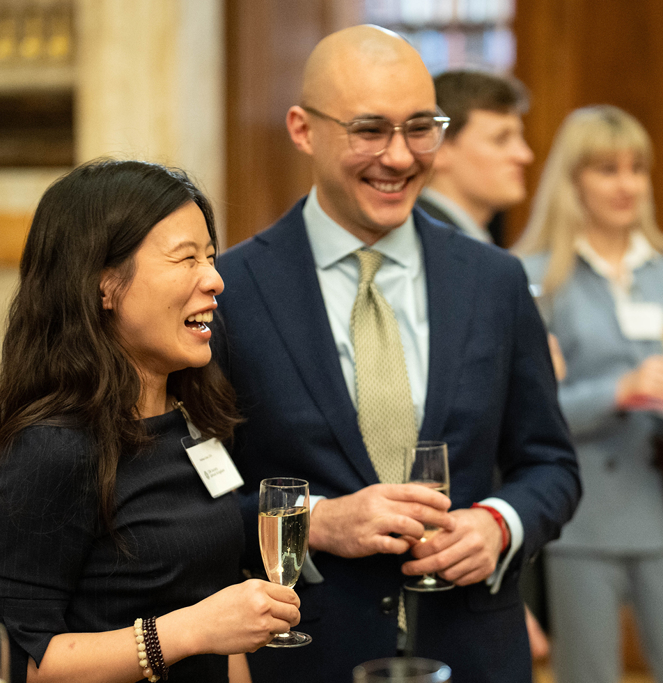 Female and Male holding drinks and laughing