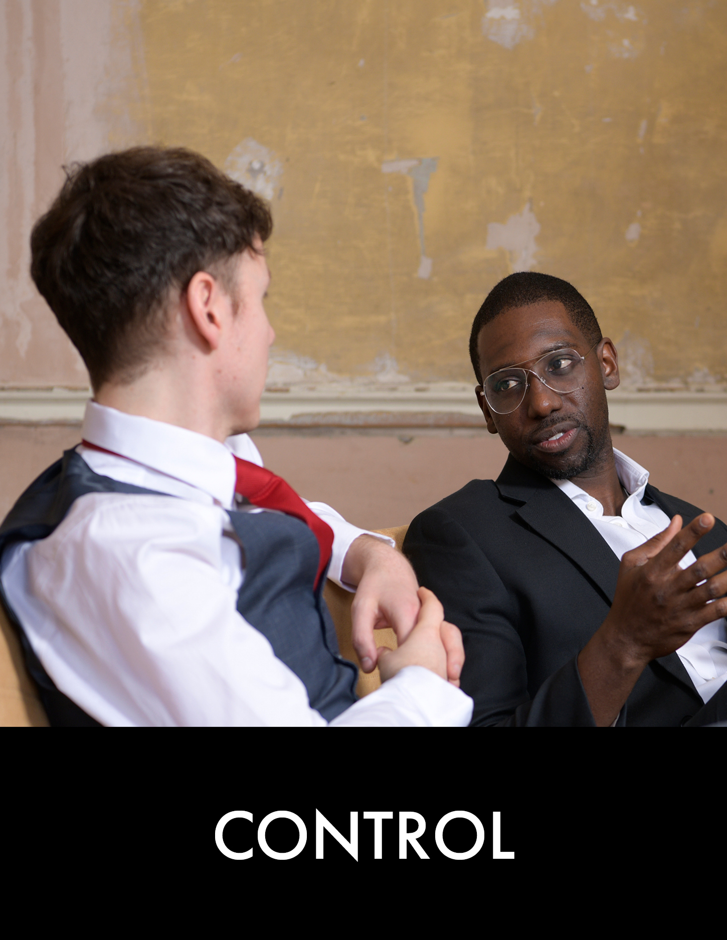 Two men having a conversation on a sofa